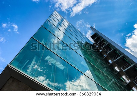 Environmental sustainable building with glass exterior, couds visible