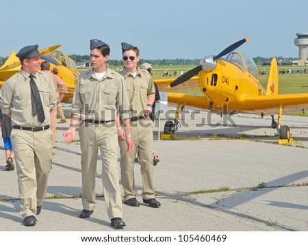 MOUNT HOPE , ONTARIO, CANADA - JUNE 16: a group of unnamed young men in vintage Air Force uniform passing a display of vintage aircraft at the Hamilton Airshow on June 16, 2012 in Mount Hope, Canada