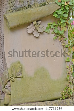 closeup of a weathered scroll shaped stone tablet  with Ivy climbing up the side