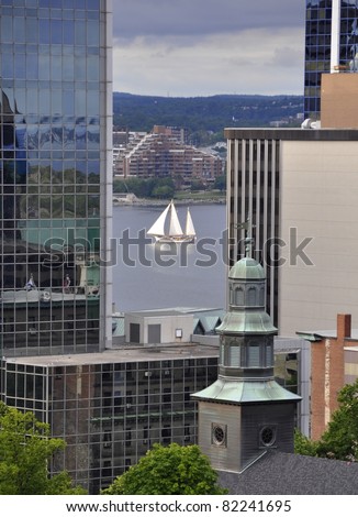 looking from the past the tall buildings of downtown Halifax towards the harbor, Tallship sailing by in between the buildings; Halifax Nova Scotia Canada