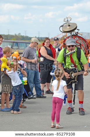 ANCASTER, ONTARIO, CANADA - SEPTEMBER 24: A crowd gathers around an unidentified one-man band entertainer at the Ancaster Fair on September 24, 2011 in Ancaster, Ontario, Canada