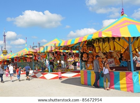 ANCASTER, ONTARIO, CANADA - SEPTEMBER 24: Fair visitors mingle around the colorful Games booth at the yearly Ancaster Fair on September 24, 2011 in Ancaster, Ontario, Canada