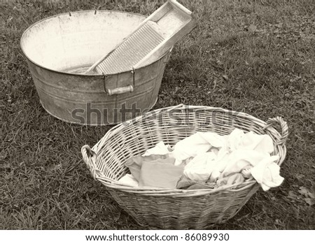old fashioned laundry equipment, washboard and tub beside a basket of laundry, vintage colors