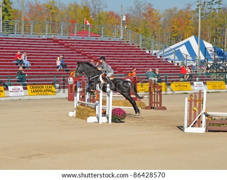 ROCKTON, ONTARIO, CANADA - OCTOBER 08: Unnamed rider and horse jumping a obstacle at the Youth Equestrian competition  at the Rockton World\'s Fair, on October 08, 2011 in Rockton, Ontario, Canada