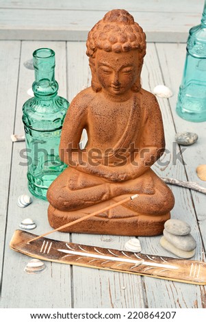 Buddha with incense and green blue bottles