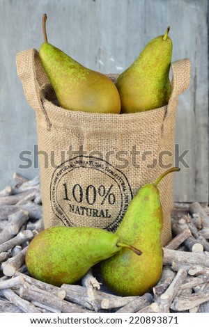 Pears in a jute bag with a wooden background