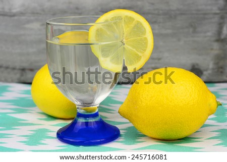 glass of cold or hot lemon water on a colored doily
