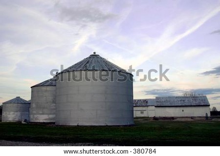 Farm silos set against the sunset.
