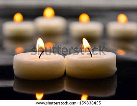 White burning candles on blurred out background