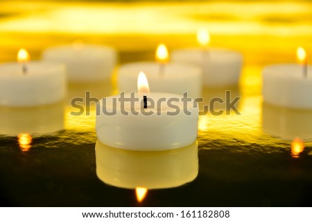picture of white burning candles on blurred out background