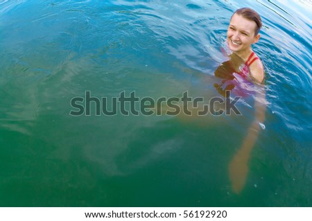 a young girl swimming in the river on a sunny day