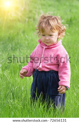 Little girl walks on the field. Summer walk.