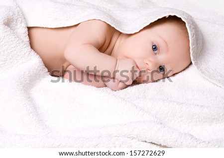 smiling baby wrapped in white towel