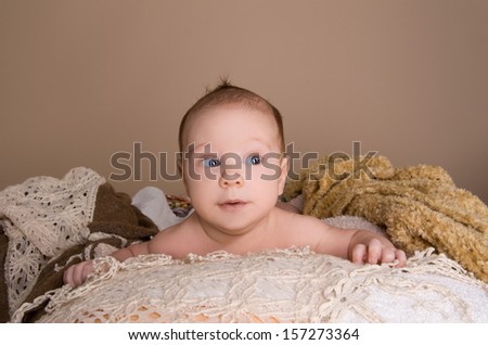 newborn baby wrapped in  light brown soft fluffy cloth on beige background