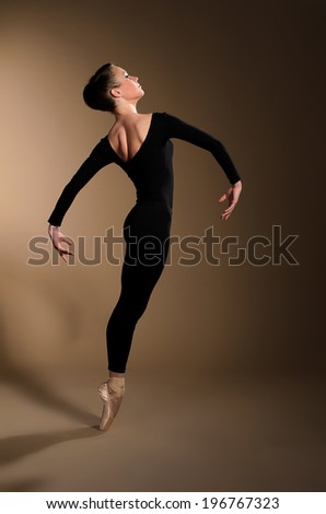 ballet dancer in jump on beige background
