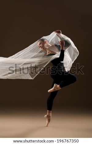 ballet dancer in jump on beige background