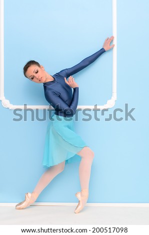 ballet dancer on tiptoe on blue wall background