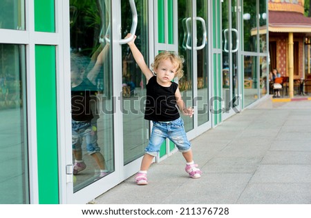little girl trying to open the doors to the building