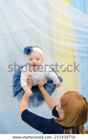 Mom tosses up a daughter in the room