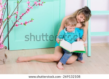Mom and son reading a book while sitting on the floor