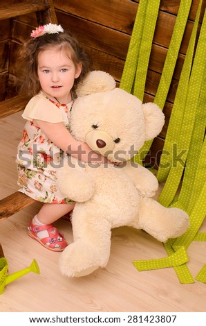 little girl hugging big teddy bear indoors