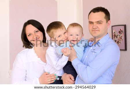 family portrait with mother, father, elder and younger sons indoors