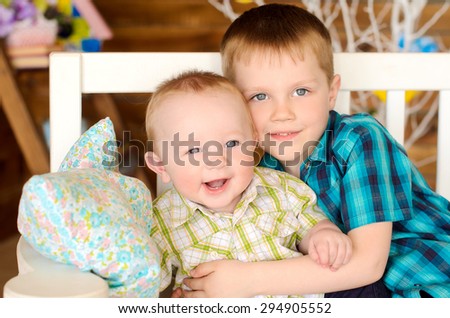 elder and younger brothers kids sitting on bench indoors