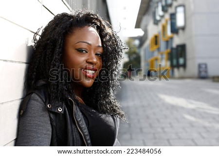 Close up Pretty Young Curly Hair Black Woman Leaning on the Wall at Street Side.