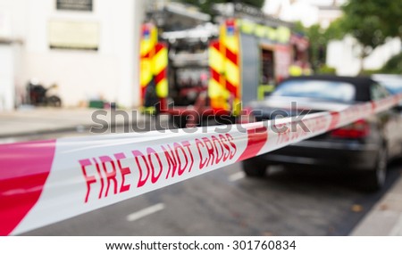 London, UK - 31st July 2015 - Fire Do Not Cross tape with fire engine in background