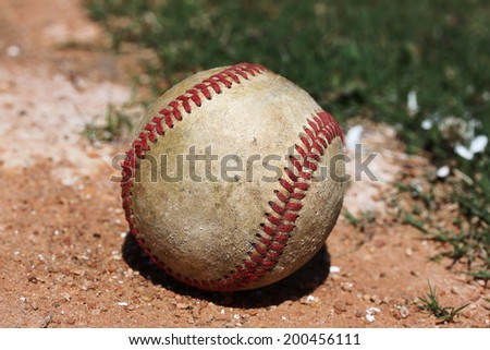 Baseball Sitting on Dirt Field