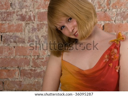 portrait of young blond woman near brick wall