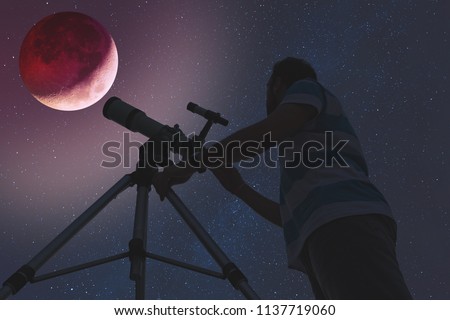 Man looking at lunar eclipse through a telescope. My astronomy work.