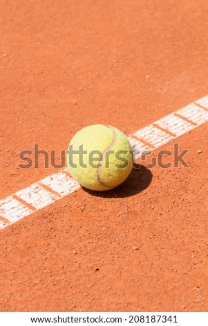 Tennis ball on clay court.