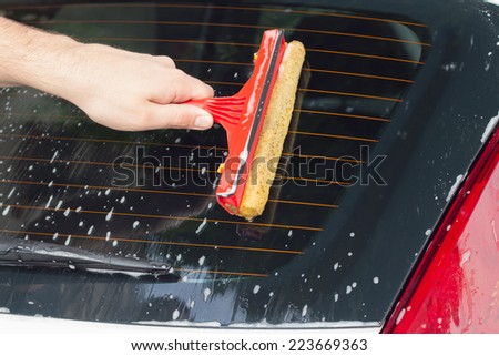 Cleaning the back windshield.
