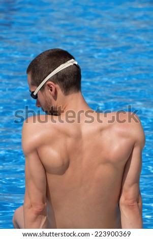 Swimmer taking a rest at the edge of a pool.