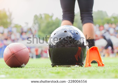 American football equipment with defocused player in the background.