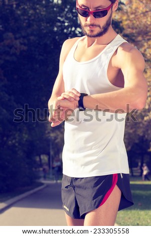 Jogger checking his running time in the park.
