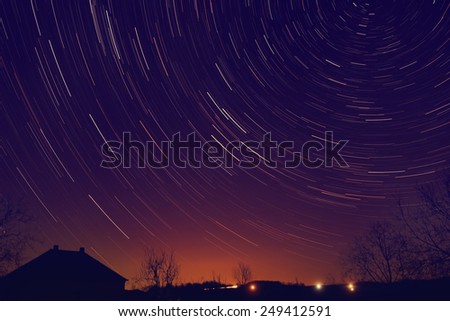 Star-trails around Polaris with suburb surroundings and city halo in the background.
