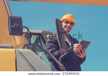 Construction engineer making notes from a excavator.