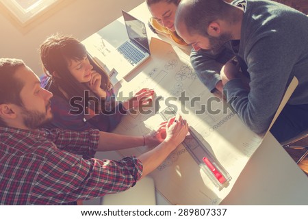 Young group of people/architects discussing business plans.