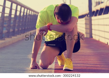 Tired urban jogger making a pause after forcing his body on a big bridge.