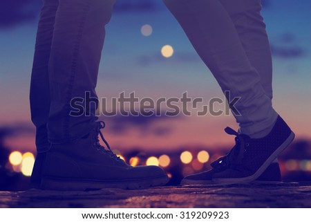 Couple in love on the street with defocused city lights and traffic.