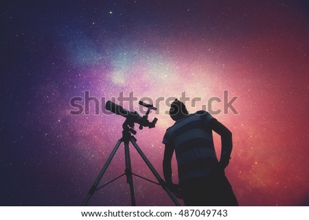 Man looking at the stars with telescope beside him. My astronomy work.