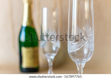 Detailed view of empty glass with champagne bottle to open.