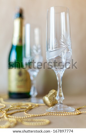 Vertical view of empty glass with champagne bottle to open.