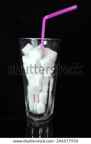 Sugar cubes in glass on black background