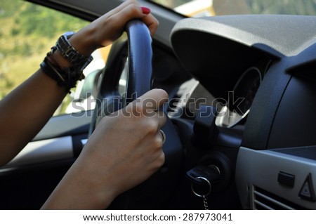 Hands of a woman on a wheel driving