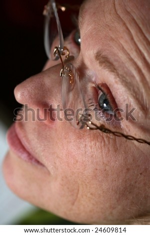 Profile of the face of woman with glasses. Skin with freckles, no make-up. Grey eyes