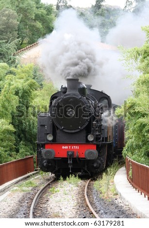 Historic steam engine with heavy dark grey smoke. Southern France near Nimes