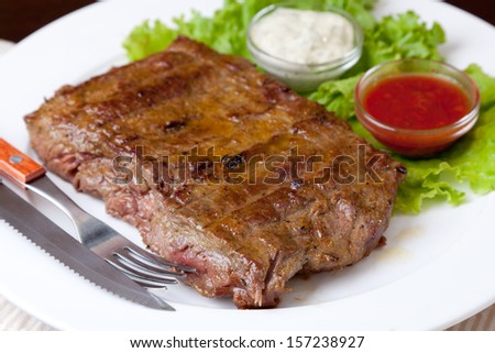 Grilled steak on a white plate